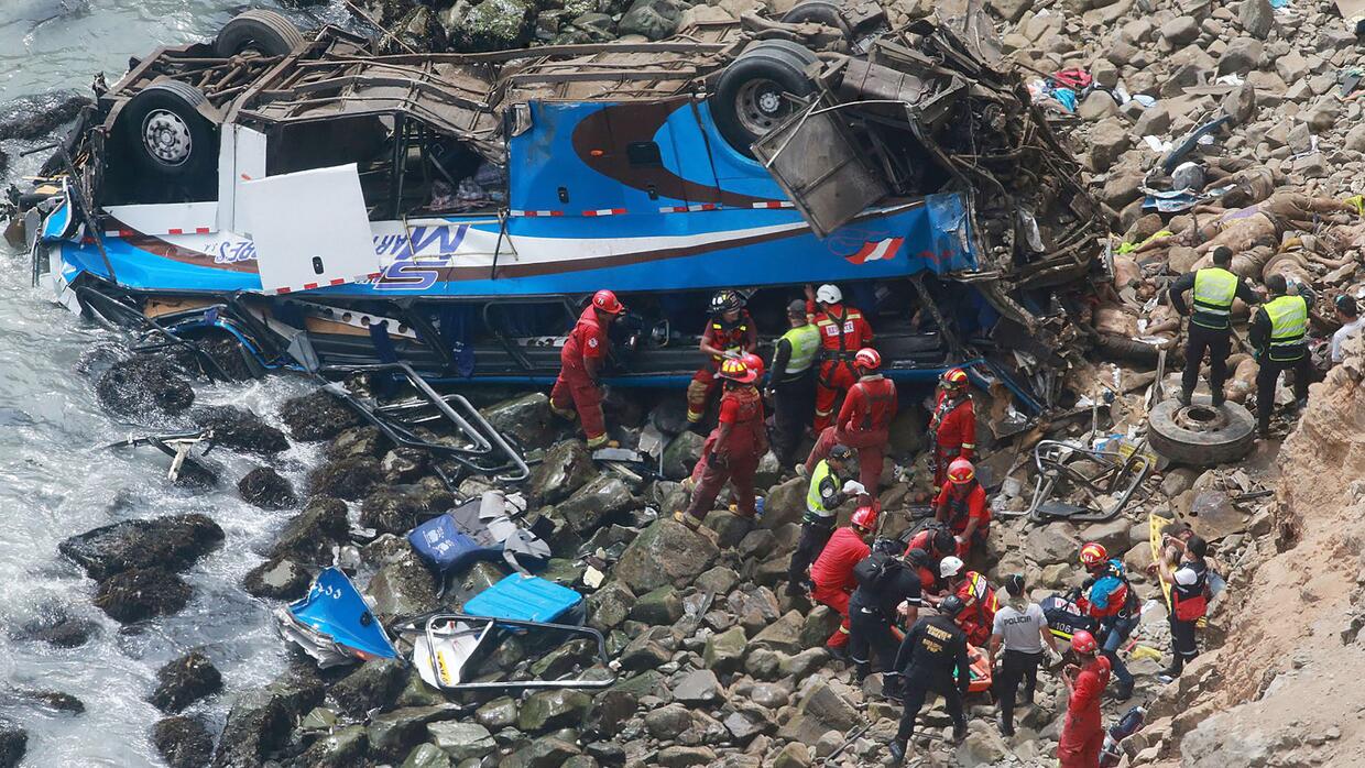 Un grupo de bomberos y policías durante las labores de rescate de un aut...