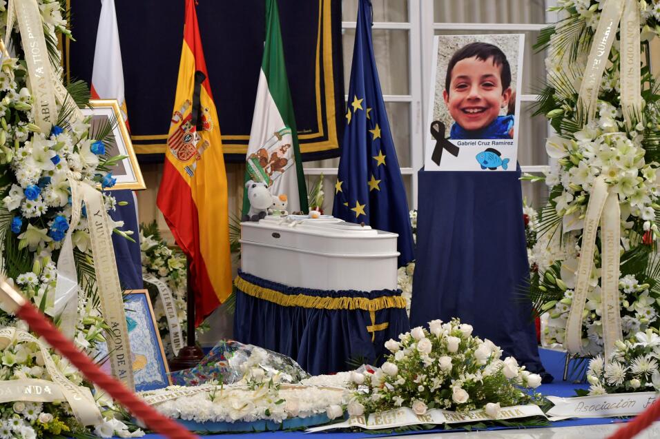 Un lazo negro junto a la imagen del menor. Ramos de flores junto al f&ea...