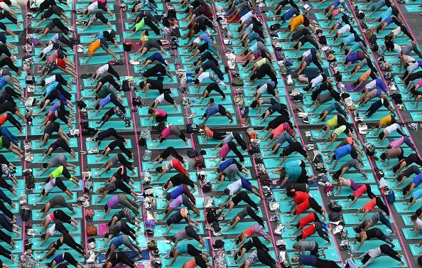 Una multitud de personas participa en una sesión masiva de yoga en Times...