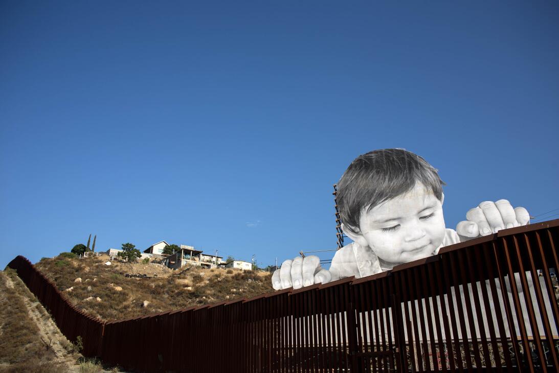 What is this curious child thinking as he peers over the border wall? Ge...