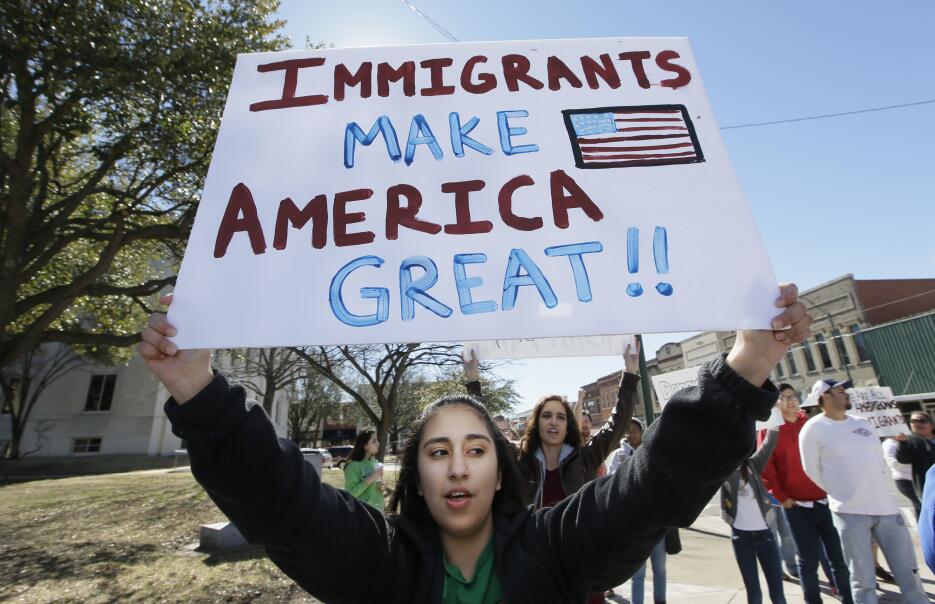 Una mujer protesta en Sherman, Texas, con un cartel que dice: "Los inmig...